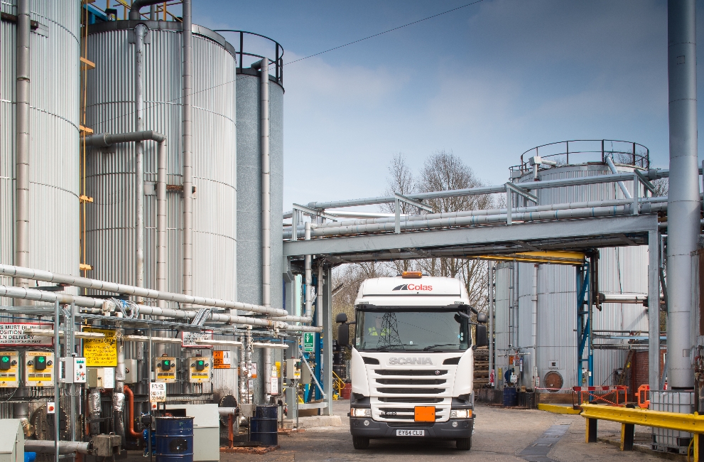 Colas truck with storage asphalt contaminates in the backgound