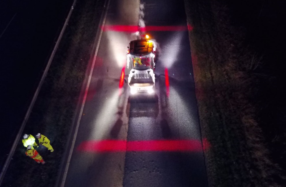 Colas Safety Exclusion Zone marked with red and blue lighting, roadworks at night with plant vehicle and workers.